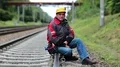 Railway worker sits on railway line HD Footage