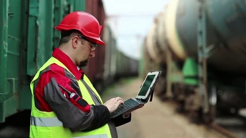 Railway worker with tablet pc near freight trains Stock Footage