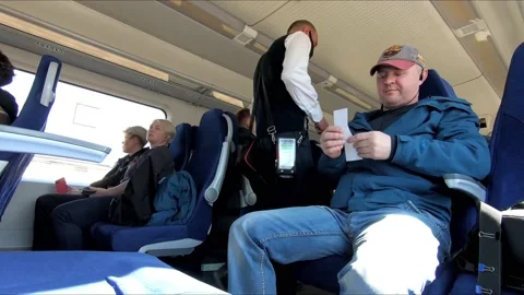 A railway worker on the train checks tickets from train passengers Stock Footage 172549790