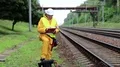 Railway worker in yellow uniform and white hard hat with documents in hands HD Footage