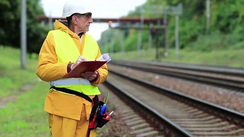 Railway worker in yellow uniform with documents Stock Footage