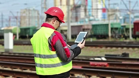 Railwayman with computer at freight train terminal Video stock 83712226
