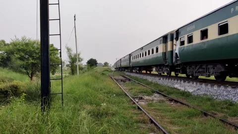 Railways train moves across rural pakistan under sun Stock Footage 317486589