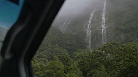 Rain and fog falling on a waterfall from inside a car, in New Zealand Stock Footage 219110001