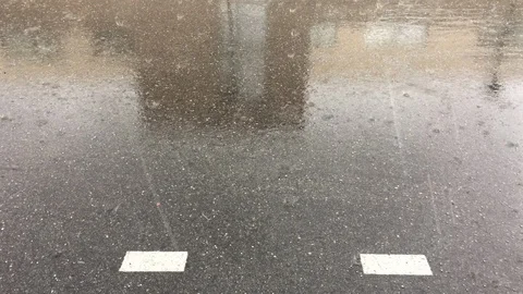 Rain and hail falling on the asphalt, during a stormy day Stock Footage 129192520
