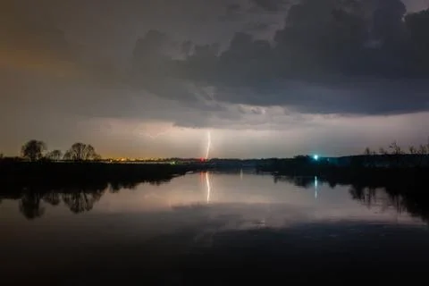Rain and lightning above the river Stock Photos