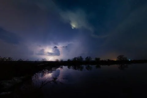 Rain and lightning above the river Stock Photos