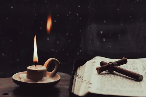 Rain and raindrops falling on the window, candles, crosses and bibles Stock Photos