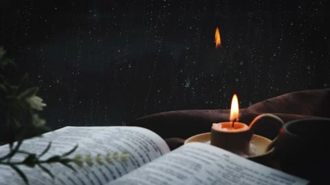 Rain and raindrops on the window and the sound of rain and candles and the Bible Stock Footage 200192413