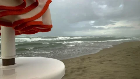 Rain on the beach. Raindrops drip from a wet folded parasol against a Stock Footage 164526912
