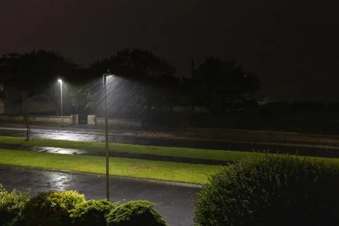 Rain blown by a strong wind captured in the light of a street lamp at night. Stock Photos
