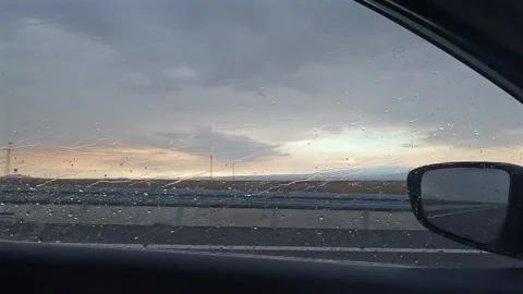 Rain clearing beyond car side window, close view, during road travel in Turkey Video stock 343805246