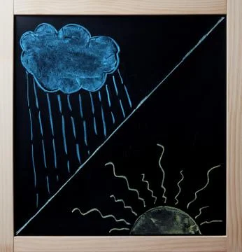 Rain cloud and beaming sun drawn on blackboard Stock Photos