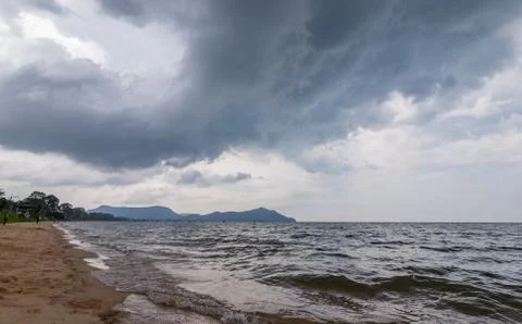 Rain cloud over the beach, mountain and sea water. Foto stock