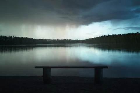 Rain cloud over a forest lake Stock Photos