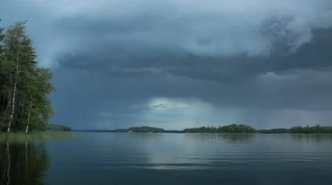 Rain clouds approaching behind a calm lake Stock Footage 54507799