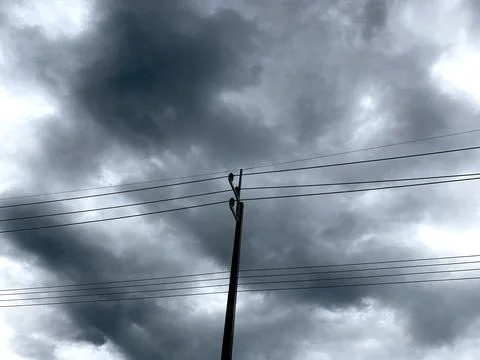 Rain clouds background with electric poles and wires Photos