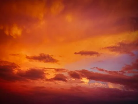 Rain clouds colored by the light of the setting sun Stock Photos