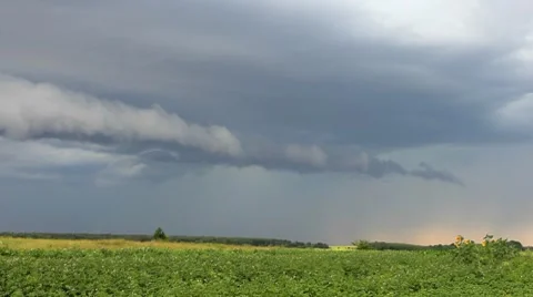 Rain clouds flying on sky over green field time-lapse Stock Footage 8559041