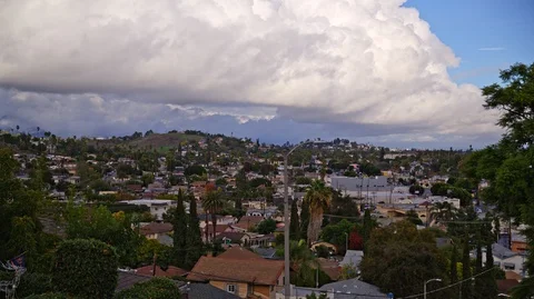 Rain Clouds over a city suburb with light rays Stock Footage 126480159