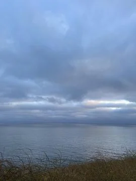Rain Clouds Over the Pacific Ocean and Cliffside Bushes in California Stock Photos