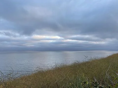 Rain Clouds Over the Pacific Ocean and Cliffside Bushes in California Stock Photos