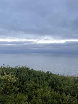 Rain Clouds Over the Pacific Ocean and Cliffside Bushes in California Stock Photos