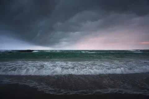 Rain clouds over the sea at sunset Stock Photos