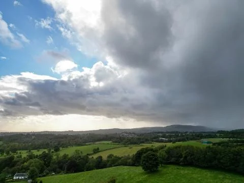 Rain clouds passing over green pasture fields Stock-Fotos