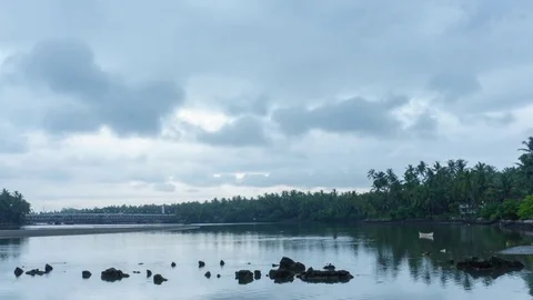 Rain clouds passing over a river Surrounded by green coconut tress Stock Footage 78171999