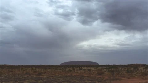 Rain clouds passing over Uluru time lapse video Stock Footage 130228154