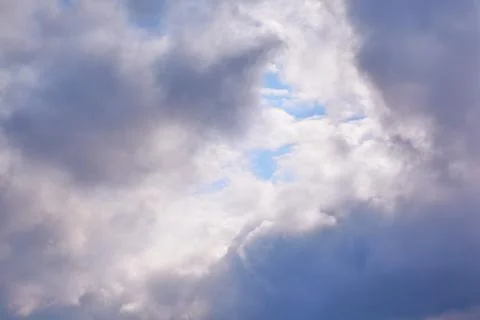 Rain clouds in the sky through which the blue sky is visible, light through g Stock Photos