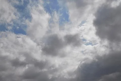 Rain clouds in the sky through which the blue sky is visible, light through g Stock Photos