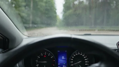 Rain covered windshield view from car interior with dashboard, illuminated Stock Footage 344772785