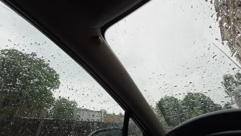 Rain covered windshield view from car interior showing heavy raindrops on glass Stock Footage 345128947