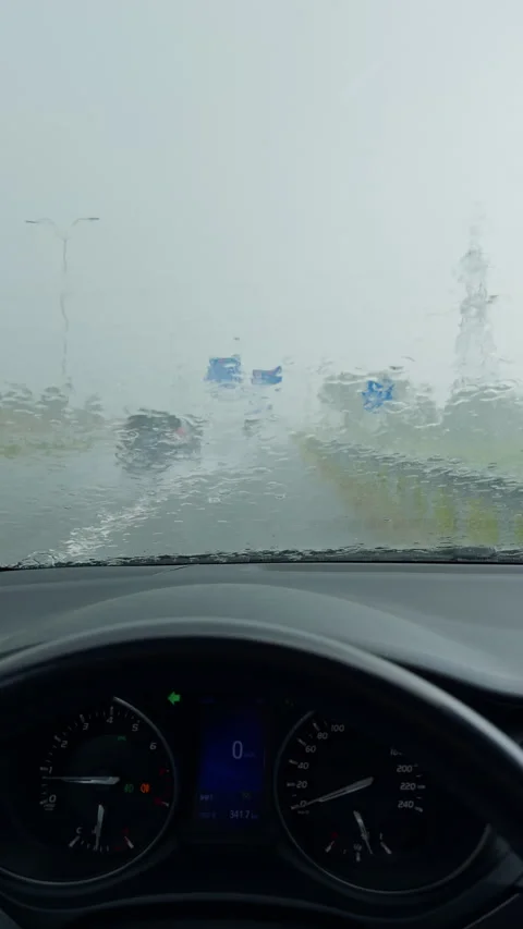 Rain covered windshield view from car interior during heavy downpour with Stock Footage 345452777