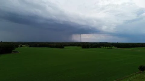 Rain, dark clouds and a landscape with trees Stock Photos