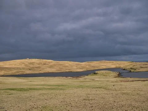 Before rain, dark clouds over a treeless landscape and lochen (small lake) Stock Photos