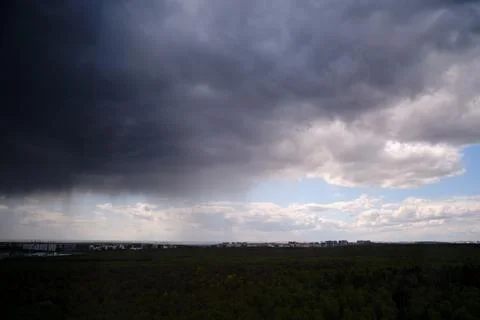 Rain dark clouds in the sky during a storm in a dramatic sky Stock Photos
