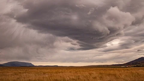 Rain from dark storm clouds over Icelandic farmland time lapse 스톡 동영상 120835542