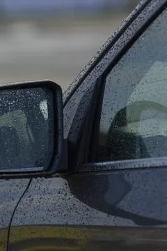 Rain-Drenched Car Side View with Reflective Mirror Foto stock