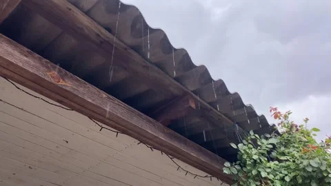 Rain Dripping from Rooftop with Sky in Background Stock Footage 313942853