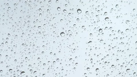 Rain drips down the glass during the day. Drops of water on a light background. Stock Footage 233031964