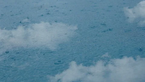 Rain drop on clear blue water surface with sky and clouds reflect on water Stock Footage 135914503