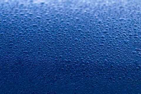 Rain drop on dark blue surface. Spring morning mood. Bright background or wal Stock Photos