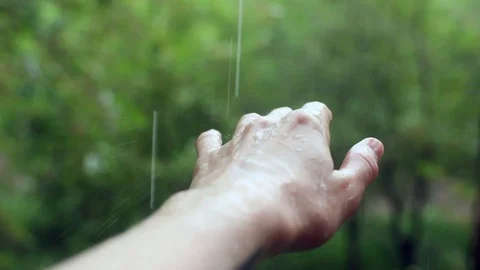 Rain drop falling down on woman girl hand in rainy day outside with green trees 스톡 동영상 93211177