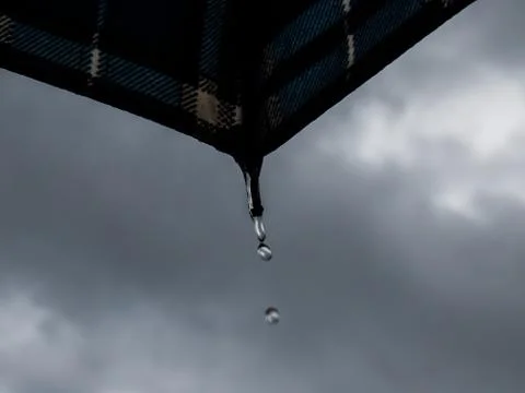 Rain drop falling from umbrella. Stock Photos