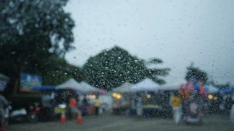 Rain drop on glass window with blur scene of people walking on street market Stock Footage 94176376