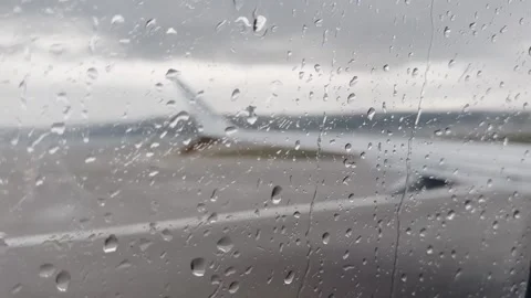 Rain droplets on an airplane window with a blurred Ryanair wing outside Stock Footage 338004220