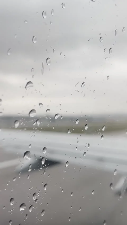 Rain droplets on airplane window as a Ryanair flight approaches the takeoff Stockbeeldmateriaal 337253436
